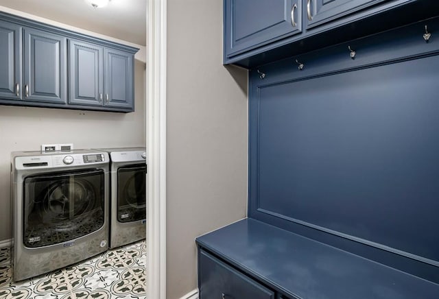 washroom with light tile patterned floors, cabinets, and washer and dryer