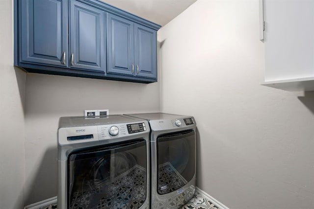 laundry room with washing machine and dryer and cabinets