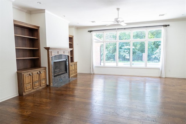 unfurnished living room featuring ceiling fan, a fireplace, ornamental molding, and dark hardwood / wood-style floors