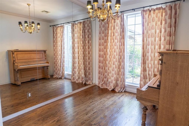 unfurnished dining area with dark hardwood / wood-style flooring, crown molding, and a chandelier