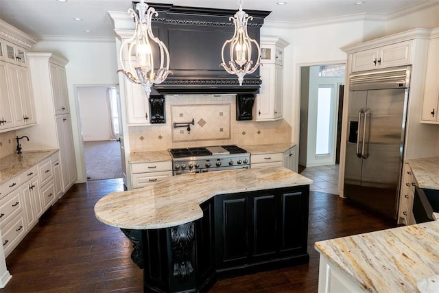 kitchen featuring light stone counters, high quality appliances, and a center island