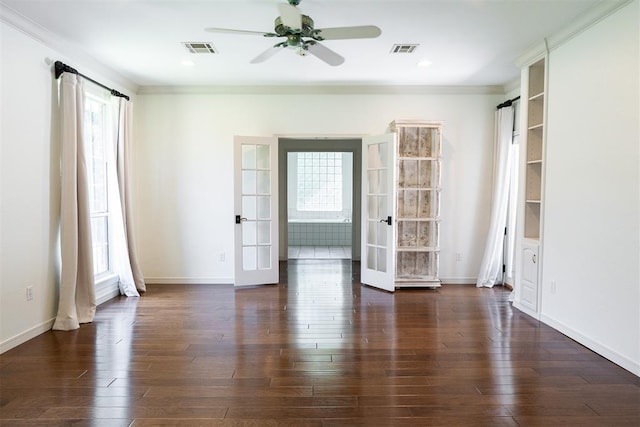 empty room featuring ceiling fan, dark wood-type flooring, ornamental molding, and french doors