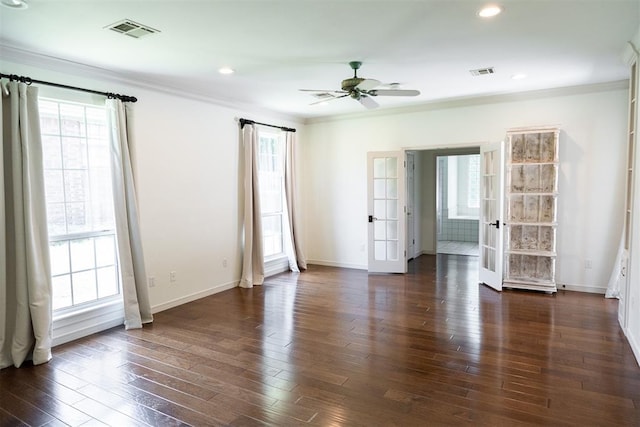 empty room featuring a wealth of natural light, dark hardwood / wood-style flooring, crown molding, and french doors