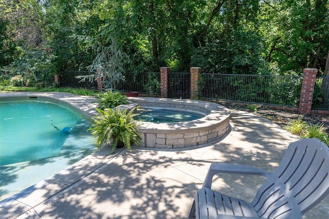 view of pool featuring an in ground hot tub and a patio