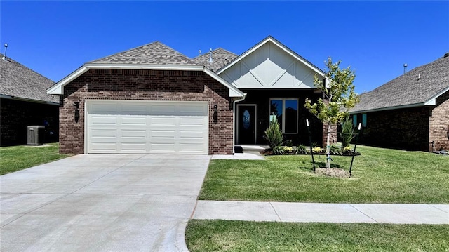 view of front of home featuring a front lawn, central AC unit, and a garage