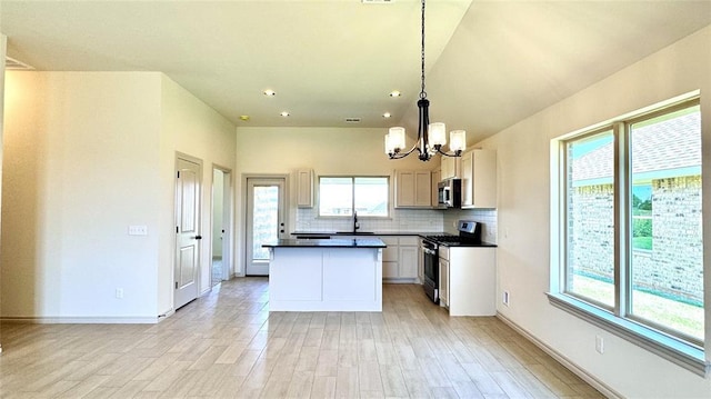 kitchen with stainless steel appliances, tasteful backsplash, light wood-type flooring, hanging light fixtures, and a center island