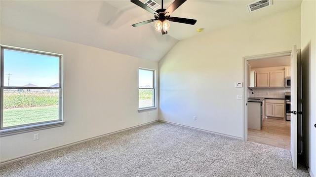 carpeted empty room featuring ceiling fan, sink, and lofted ceiling