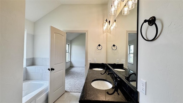 bathroom with a washtub, vanity, lofted ceiling, and tile patterned flooring