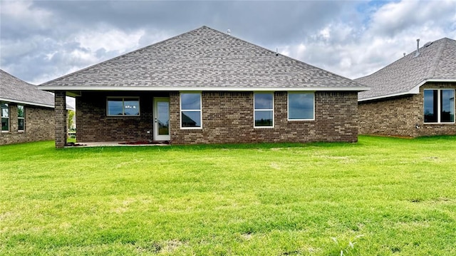 rear view of property featuring a lawn