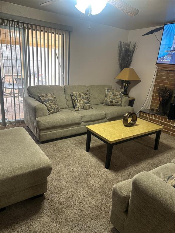 living room with a fireplace and carpet flooring