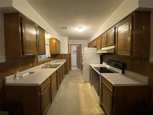 kitchen with range with electric stovetop, a sink, under cabinet range hood, wood walls, and a textured ceiling