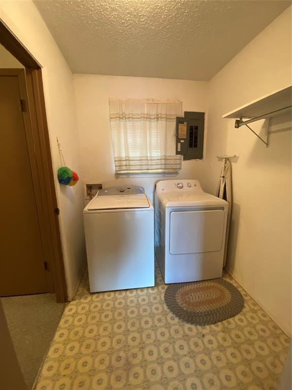 washroom with electric panel, washing machine and dryer, tile patterned floors, and a textured ceiling