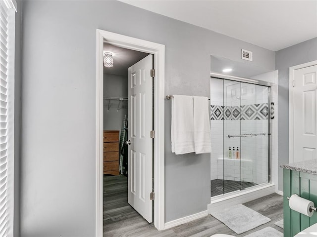 bathroom featuring a shower with shower door and hardwood / wood-style flooring