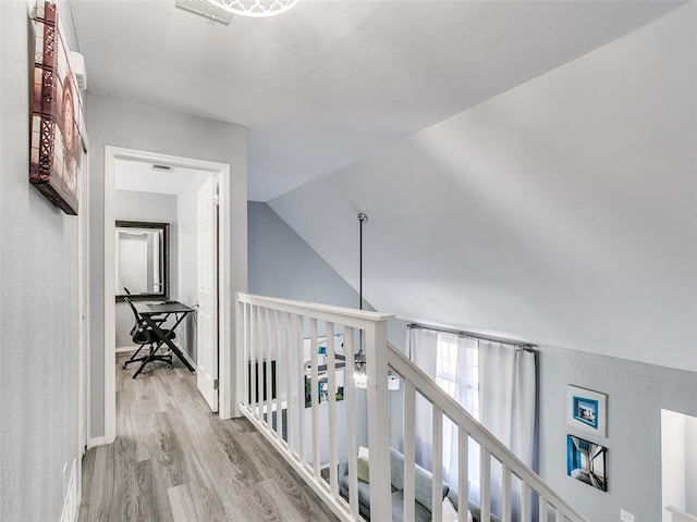 hallway featuring light hardwood / wood-style floors and vaulted ceiling