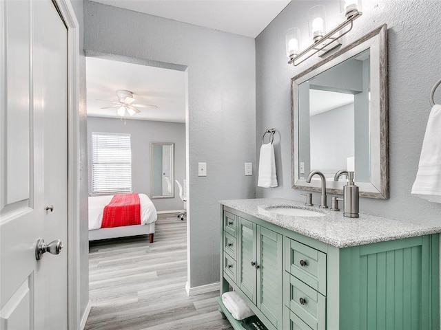 bathroom featuring ceiling fan, wood-type flooring, and vanity