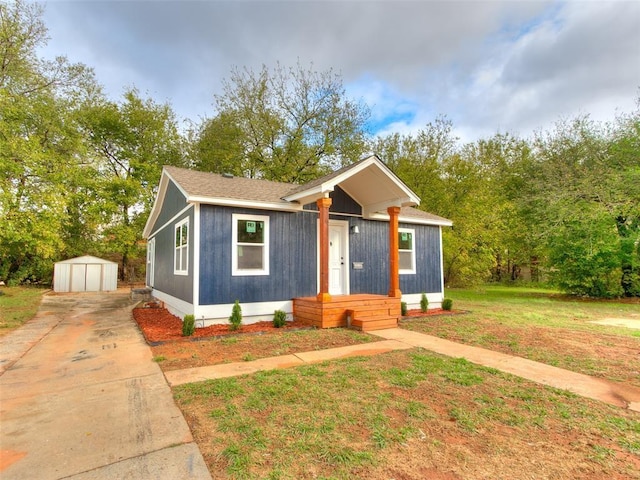 view of front of home with a front yard and a storage shed