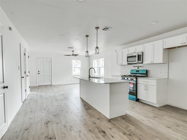 kitchen with white cabinetry, a kitchen island with sink, sink, pendant lighting, and stainless steel appliances