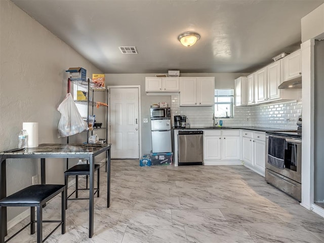 kitchen with sink, white cabinets, tasteful backsplash, and stainless steel appliances