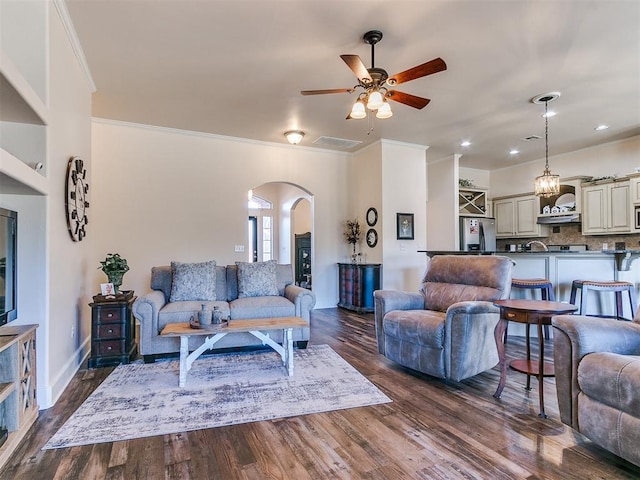 living room with ornamental molding, ceiling fan, and dark hardwood / wood-style flooring