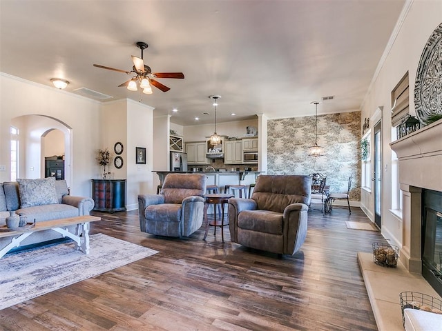 living room with ceiling fan, dark hardwood / wood-style flooring, and ornamental molding