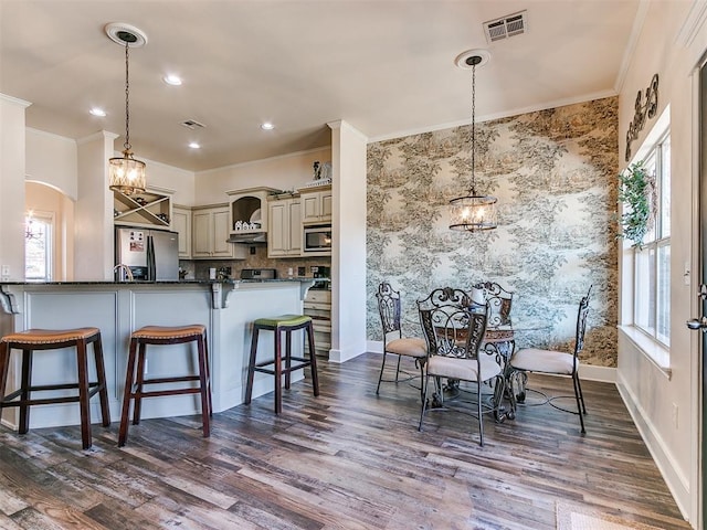 kitchen with a wealth of natural light, kitchen peninsula, and appliances with stainless steel finishes