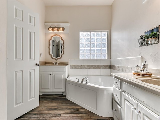 bathroom featuring a washtub, wood-type flooring, and vanity