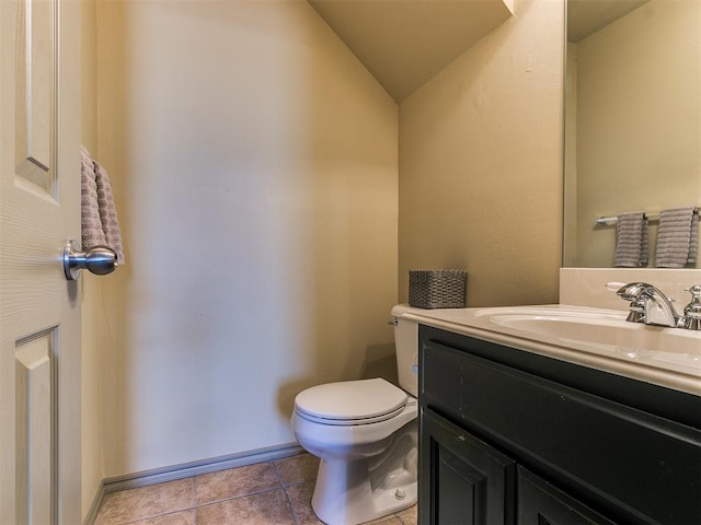 bathroom with vanity, toilet, tile patterned floors, and lofted ceiling