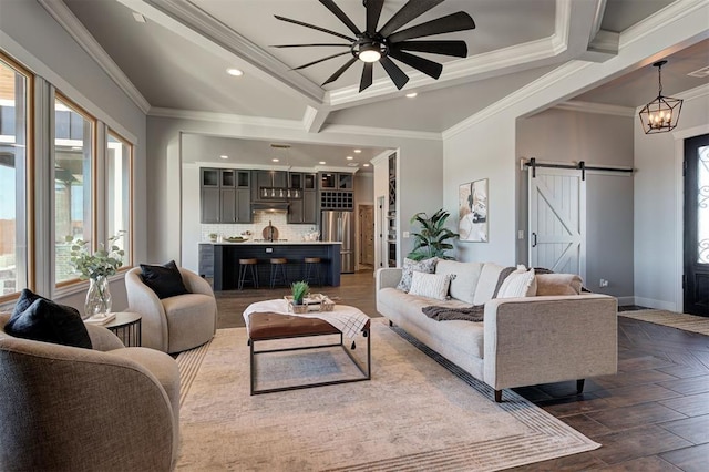 living room featuring ornamental molding, an inviting chandelier, dark hardwood / wood-style floors, and a barn door