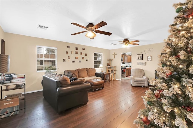 living room with a wealth of natural light, dark hardwood / wood-style floors, and ceiling fan