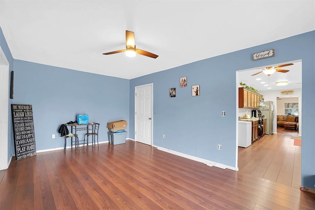 sitting room with hardwood / wood-style floors and ceiling fan