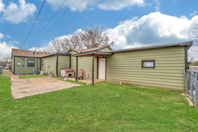 back of house with a yard, central air condition unit, and a patio area