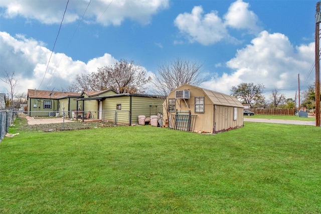 back of house with an outdoor structure and a lawn