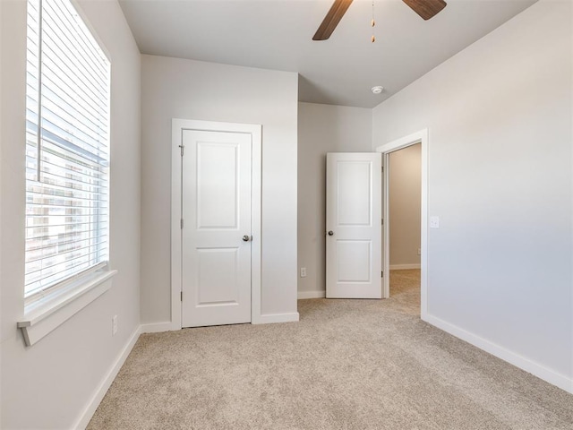 unfurnished bedroom featuring light carpet and ceiling fan