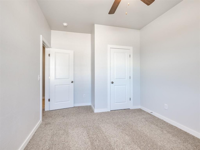 unfurnished bedroom with ceiling fan and light colored carpet