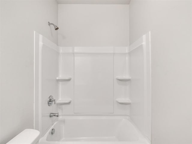 bathroom featuring tub / shower combination and toilet