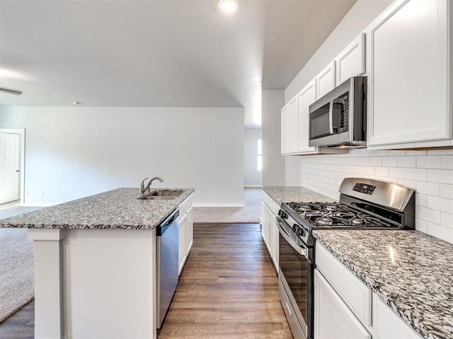 kitchen featuring sink, white cabinets, stainless steel appliances, a kitchen island with sink, and backsplash