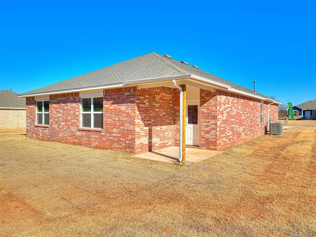 rear view of house featuring a patio, a yard, and cooling unit