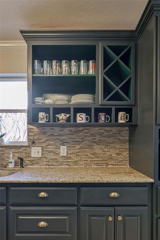 bar featuring light stone counters and ornamental molding