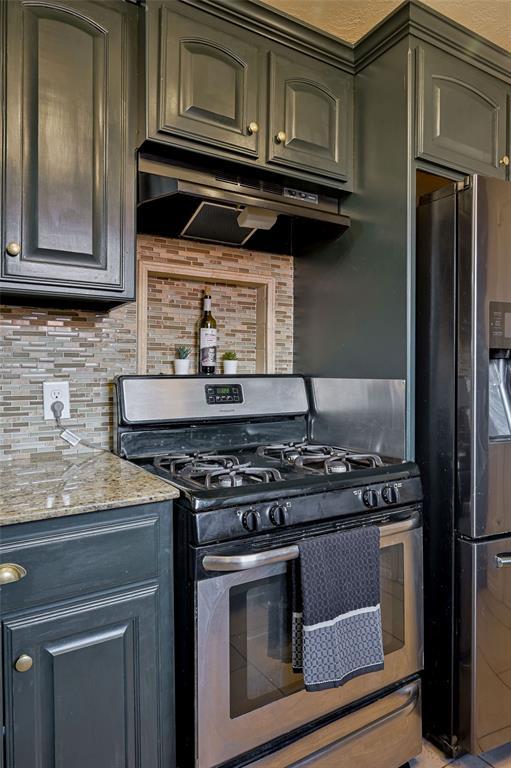 kitchen with decorative backsplash, light stone countertops, and stainless steel appliances