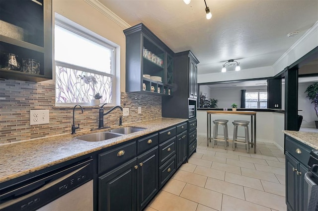 kitchen with light stone countertops, decorative backsplash, sink, light tile patterned floors, and stainless steel dishwasher