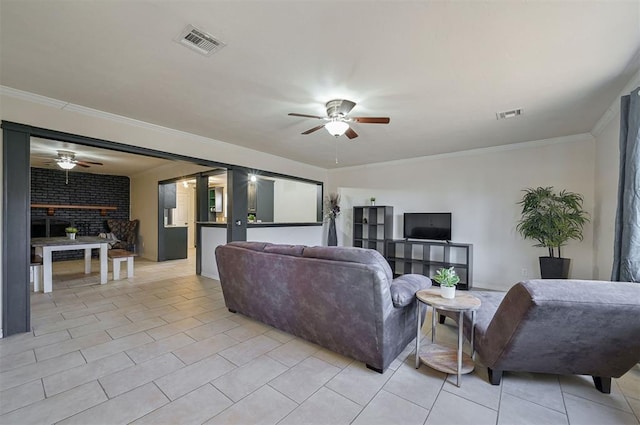 living room with ceiling fan, light tile patterned floors, a brick fireplace, and ornamental molding