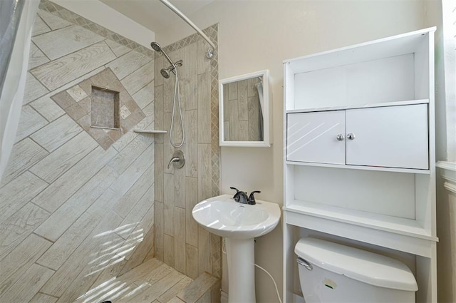 bathroom with toilet and tiled shower