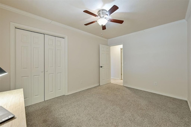 unfurnished bedroom with ceiling fan, a closet, carpet, and ornamental molding