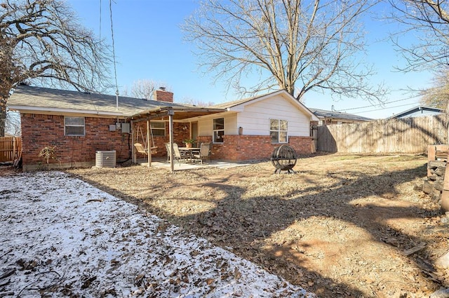 back of house with a fire pit and a patio