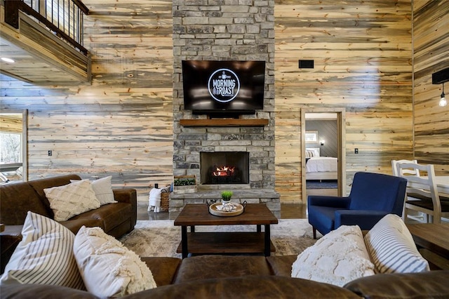 living room featuring wood walls and a stone fireplace