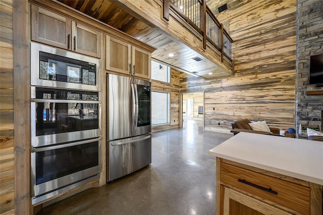 kitchen with appliances with stainless steel finishes, wooden ceiling, wood walls, and a high ceiling