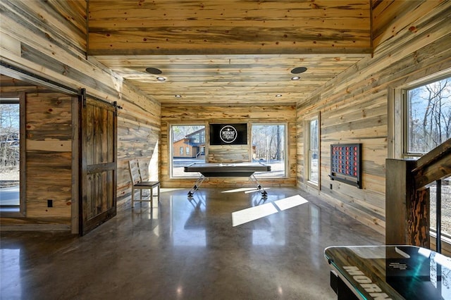 interior space featuring wood ceiling, wood walls, and a barn door