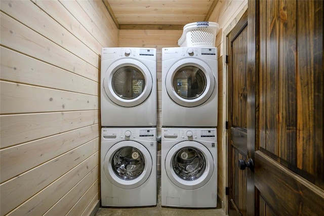 washroom featuring washer and dryer, stacked washing maching and dryer, wooden ceiling, and wood walls