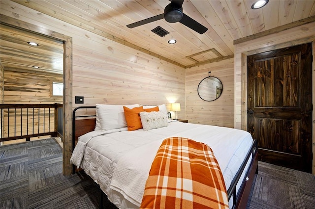 carpeted bedroom with ceiling fan, wooden walls, and wooden ceiling