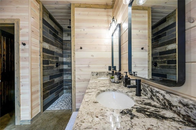 bathroom with wood ceiling, wood walls, vanity, and walk in shower